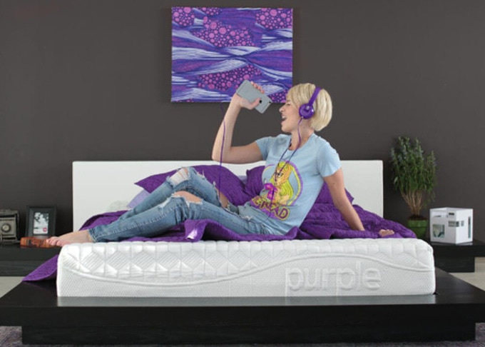 woman enjoying music on a purple mattress
